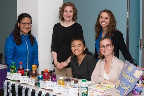 Nutrition students have a table of at a U N E health fair